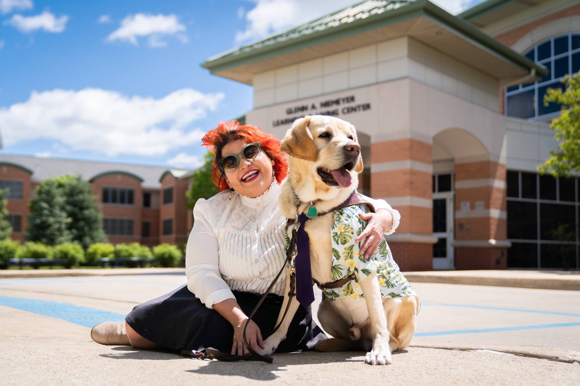 Melba V&#233;lez Ortiz smiles with her dog, Chad, outside the Meijer honors College
